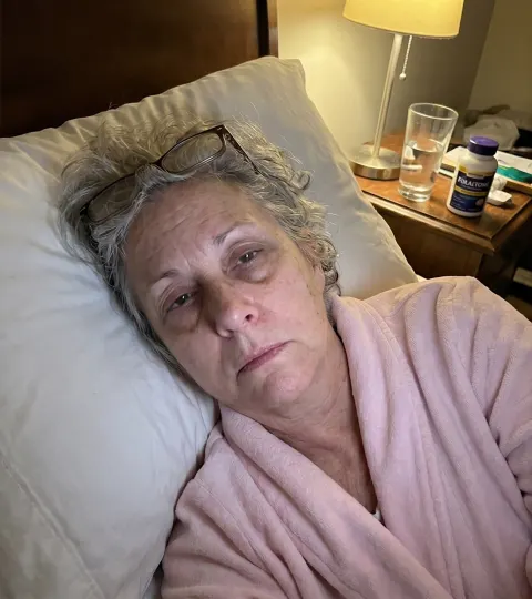 Dorothy, before — lying in bed, face drawn with tiredness